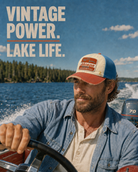 Thumbnail for A man driving a boat on a lake wearing a vintage-style blue denim shirt and a blue and orange cap with a 'Barron' logo. Large text on the left reads 'VINTAGE POWER.