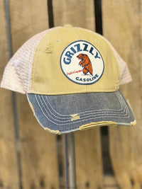 Thumbnail for A distressed trucker hat with a tan front panel, blue denim-look brim, and off-white mesh back. The front features a circular embroidered patch with the Grizzly Gasoline logo.