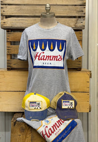 Thumbnail for A heather gray graphic T-shirt displayed on a mannequin torso, featuring a large blue, white, and red Hamms Beer logo on the chest. 