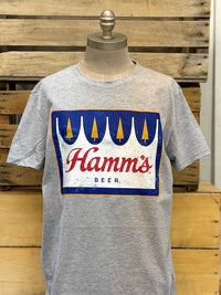 Thumbnail for A heather gray t-shirt displayed on a mannequin torso, featuring a vintage-style distressed graphic of the 'Hamm's Beer' logo in blue, red, and white.