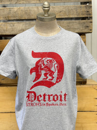 Thumbnail for A heather gray short-sleeve t-shirt displayed on a mannequin torso, featuring a large distressed red graphic of a lion inside a letter 'D' with the text 'Detroit' and 'STROHS is Spoken Act.' below it, set against a rustic wooden background.