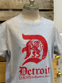 Thumbnail for A heather gray crewneck t-shirt displayed on a mannequin torso. The shirt features a large red distressed graphic of a lion inside a letter 'D' with the text 'Detroit' and 'STROHS is Spoken Here.